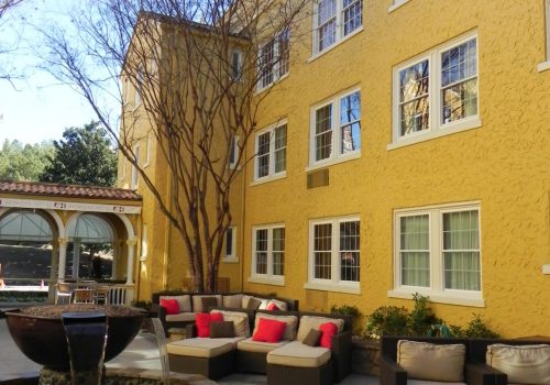 Multi-story residential building with white vinyl windows and courtyard seating area