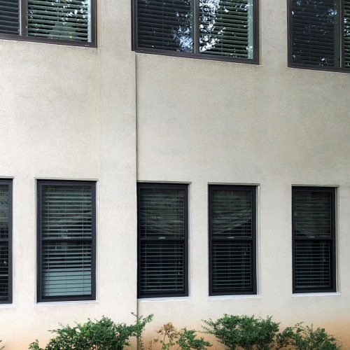 Building exterior with multiple black framed vinyl windows showcasing modern window installation